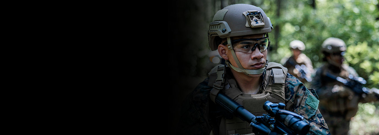 Marine in combat gear and helmet demonstrating tactical roles and specialties within Marine Corps ranks.